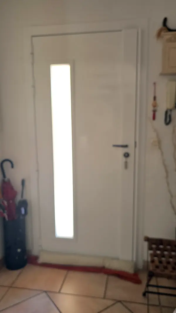 Porte d'entrée intérieure blanche à vitrage allongé vue depuis le hall à Fréjus